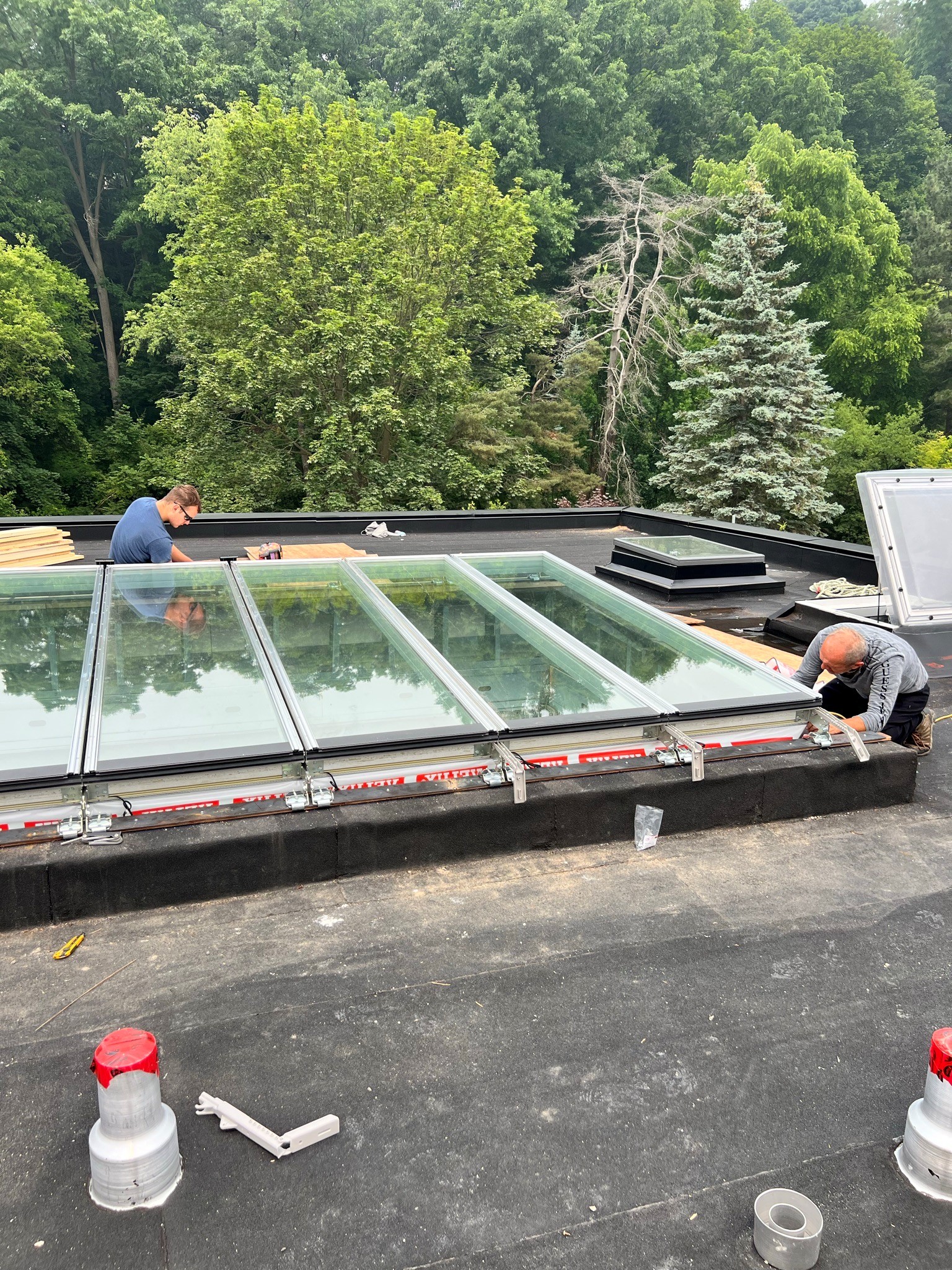 Crew installing a VELUX Modular Skylight longlight on a flat roof